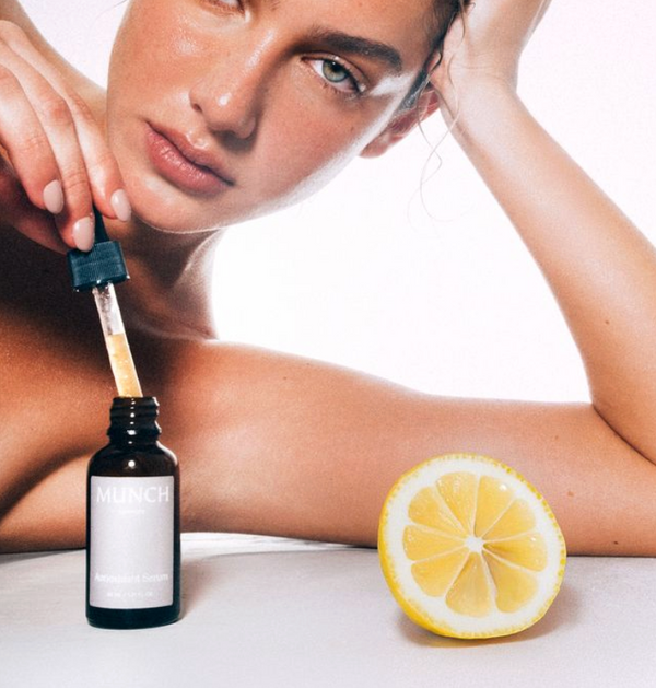 Modelo aplicando suero facial con Vitamina C 8% antioxidante para iluminar la piel