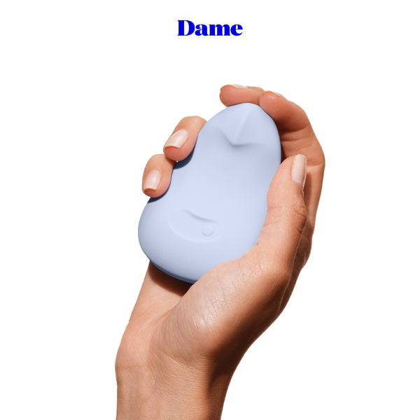 Dame Pom Palm Vibrator sostenido en la mano mostrando su tamaño pequeño y discreto