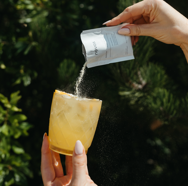 Persona preparando bebida con NOVOS Core suplemento de longevidad con NMN como parte de una rutina diaria para apoyar energía celular y envejecimiento saludable