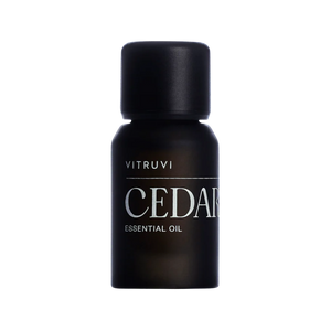 Aceite esencial de madera de cedro Vitruvi 100% puro en botella negra para aromaterapia y difusor.