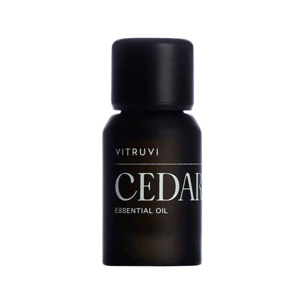 Aceite esencial de madera de cedro Vitruvi 100% puro en botella negra para aromaterapia y difusor.