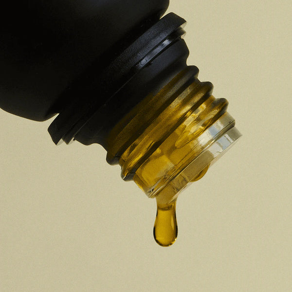 Detalle de gota de aceite esencial de madera de cedro Vitruvi 100% natural.