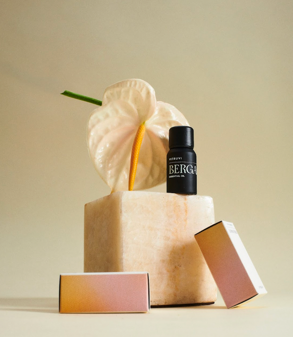 Botella de aceite esencial de bergamota Vitruvi con fondo amarillo, ideal para difusor.